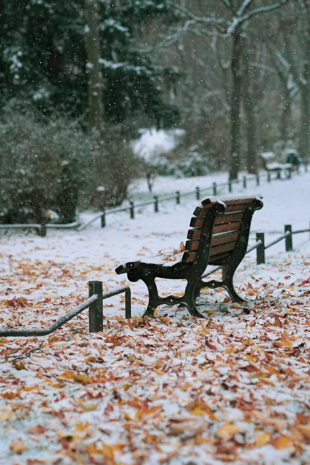 a park bench sitting in the middle of a snow covered park