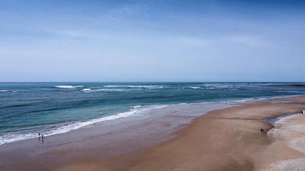 a sandy beach with waves coming in to shore