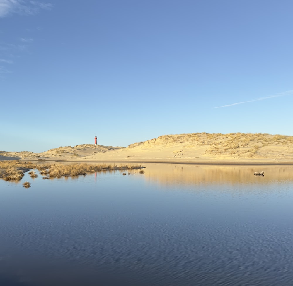 a body of water surrounded by sand dunes