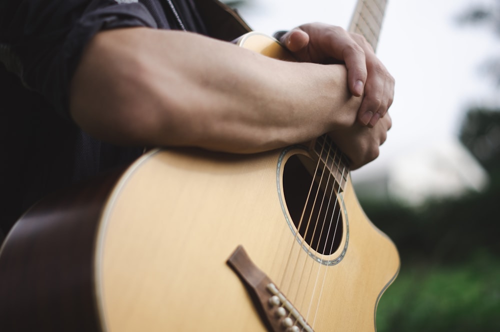 a close up of a person holding a guitar