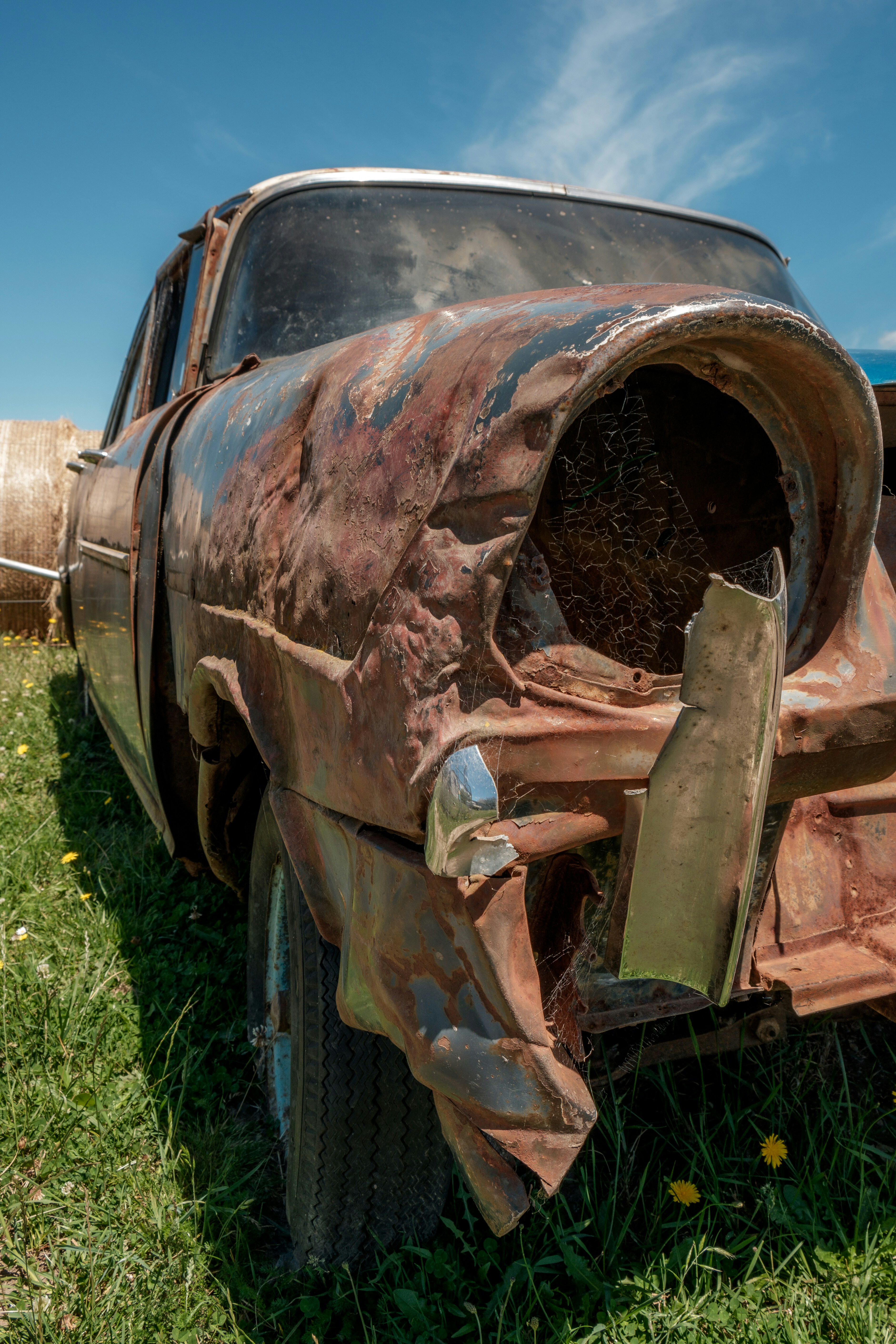 ein verrostetes Auto, das im Gras steht