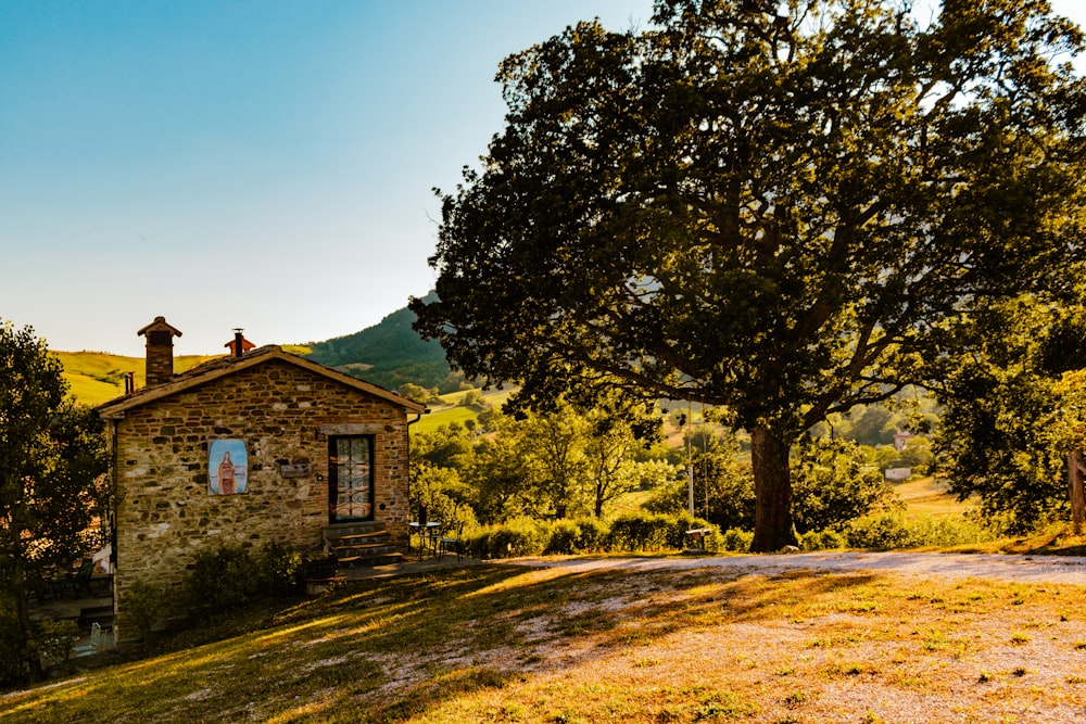 a stone building sitting on top of a lush green hillside