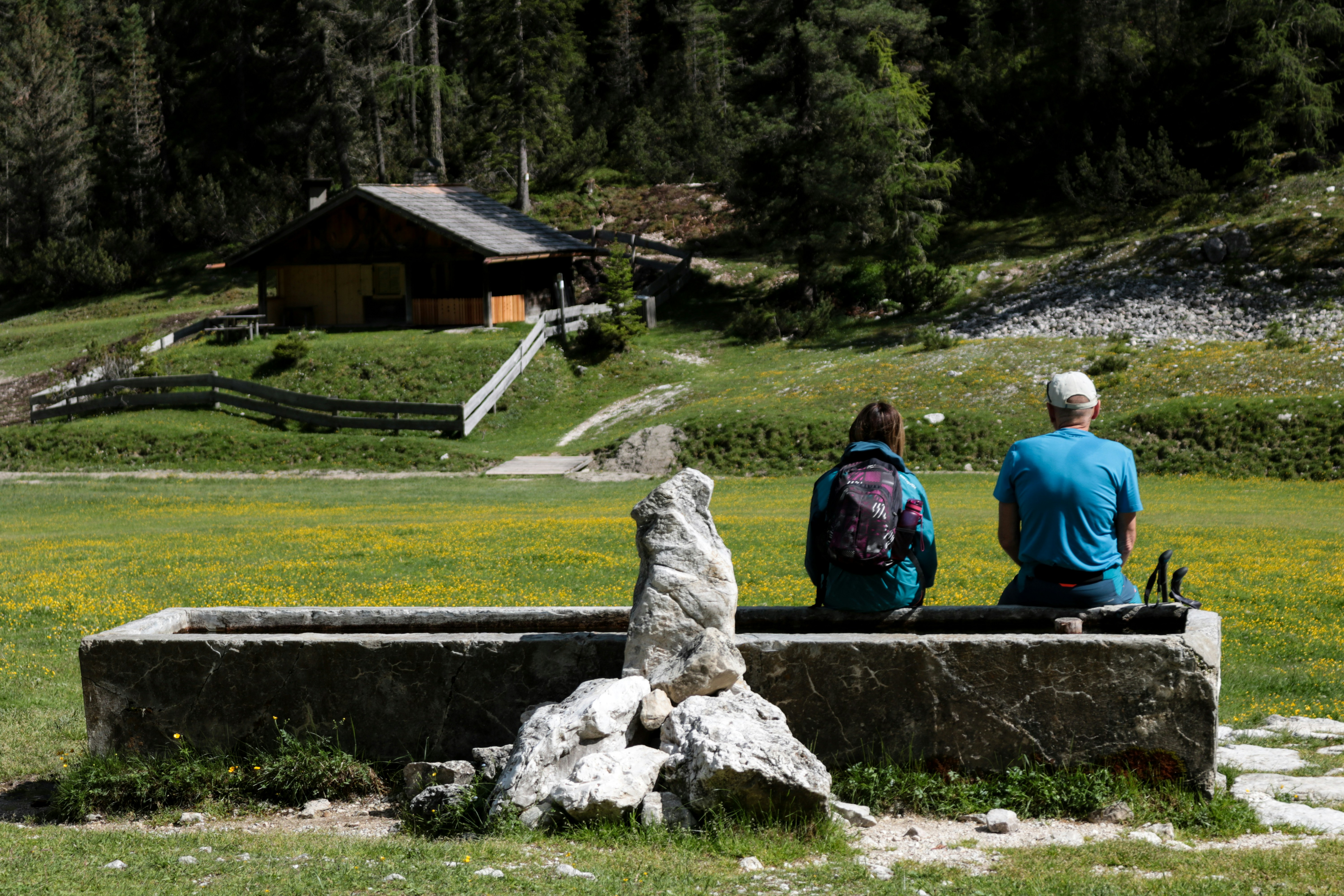 A couple of people sitting on a stone bench