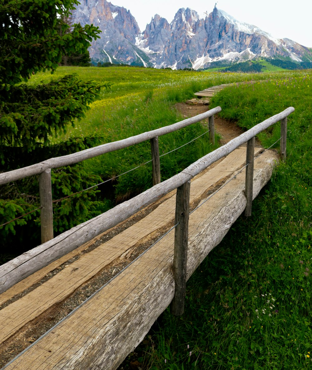 a wooden bench sitting on top of a lush green field