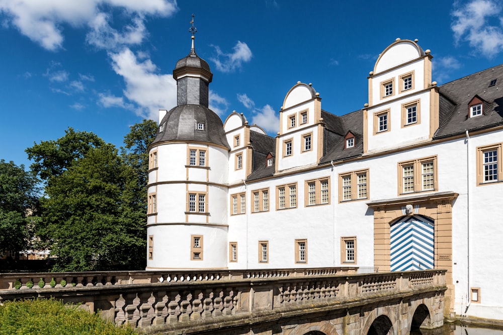 a large white building with a bridge in front of it