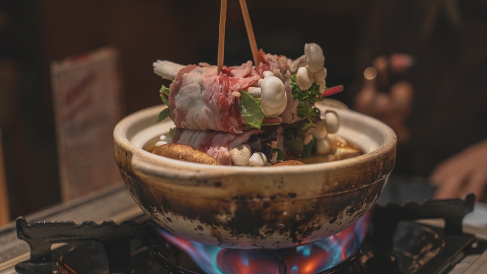 a bowl of food sitting on top of a stove