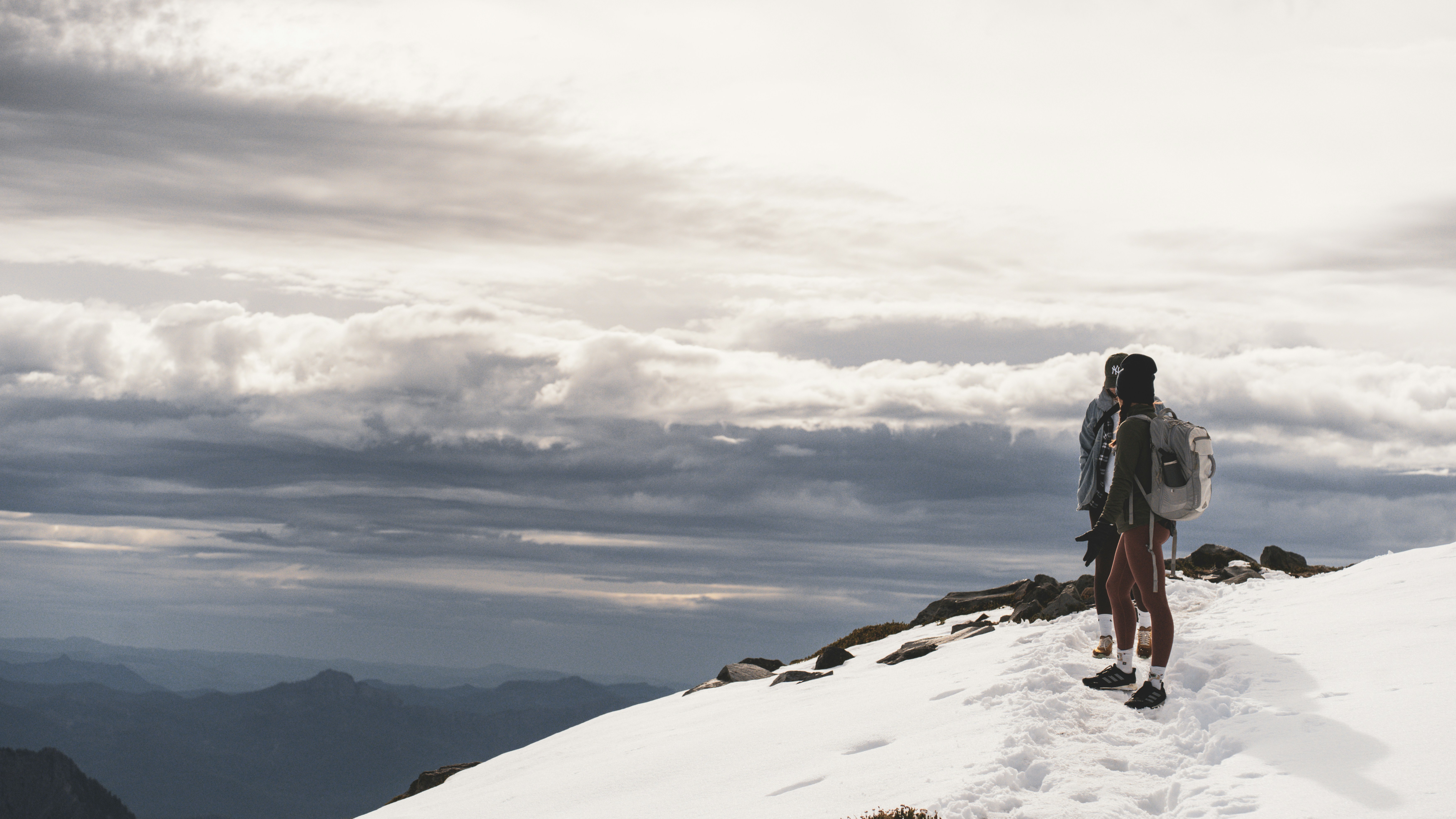 a person standing on top of a snow covered mountain, 
