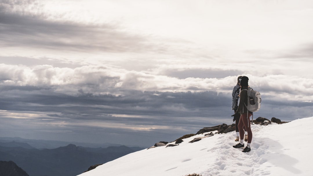 a person standing on top of a snow covered mountain,
