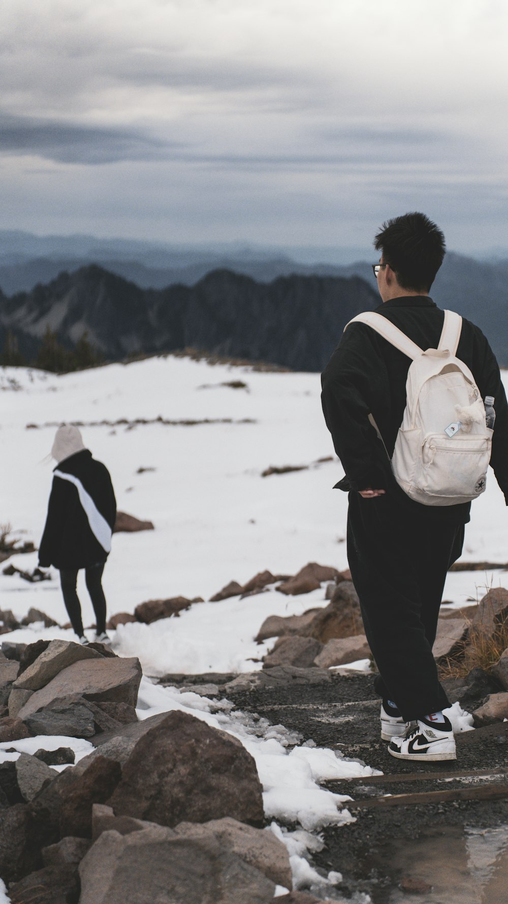 a couple of people standing on top of a snow covered slope