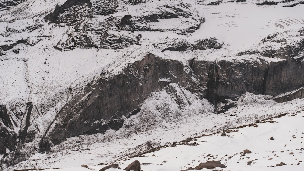 a snow covered mountain with rocks and snow