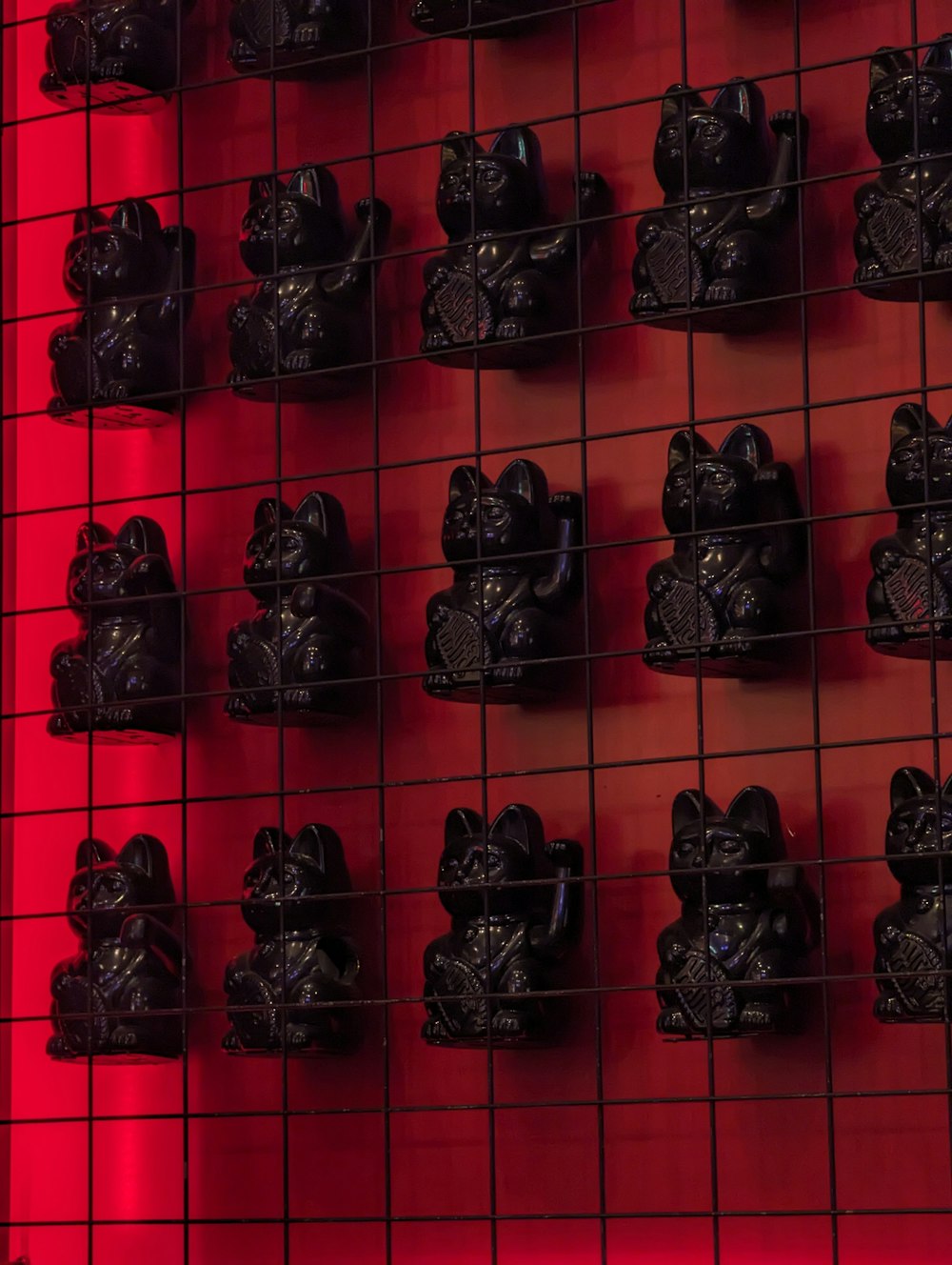 a red wall with a bunch of black figurines on it