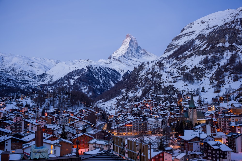 a snowy mountain is in the background of a town