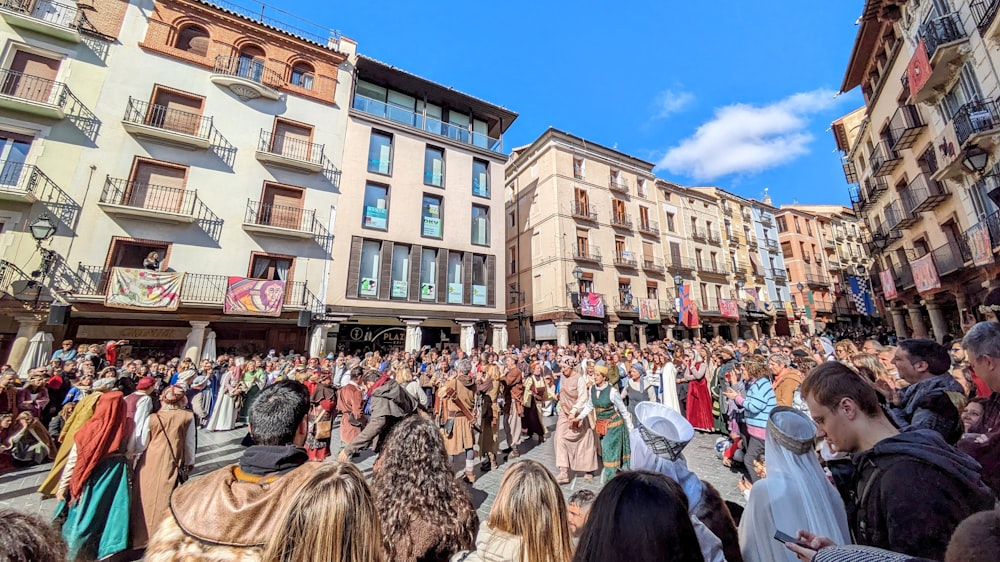 a crowd of people standing in front of tall buildings