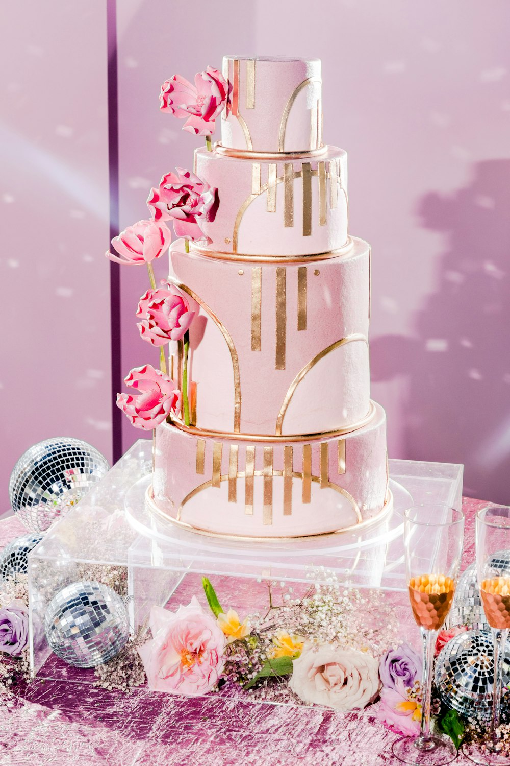 a wedding cake with pink flowers on a table