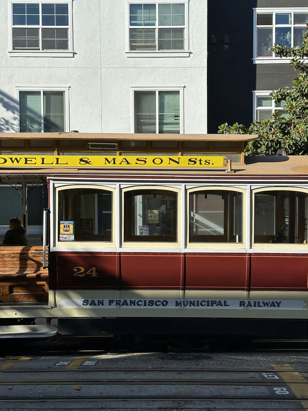 a trolley car on a city street with buildings in the background