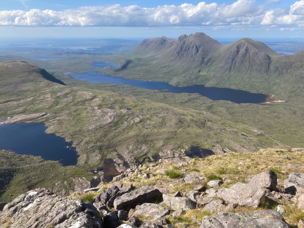 la vista desde la cima de una montaña que mira hacia abajo en un lago y montañas