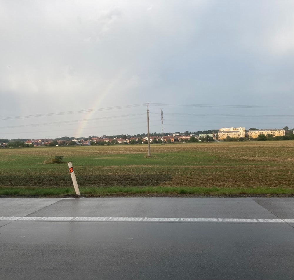 a rainbow in the sky over a field of grass