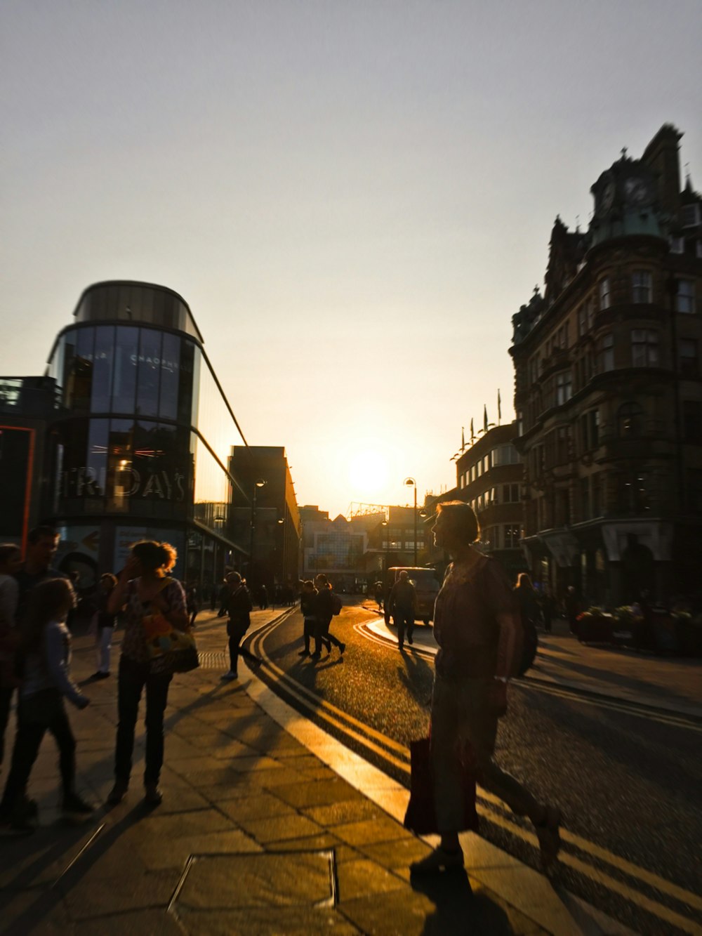 a group of people walking down a street next to tall buildings