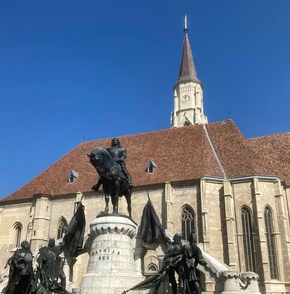 a statue of a man riding a horse in front of a church