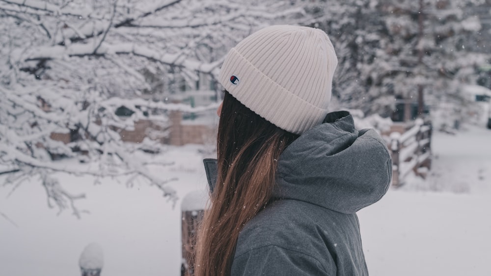 una donna in piedi nella neve con le spalle alla telecamera