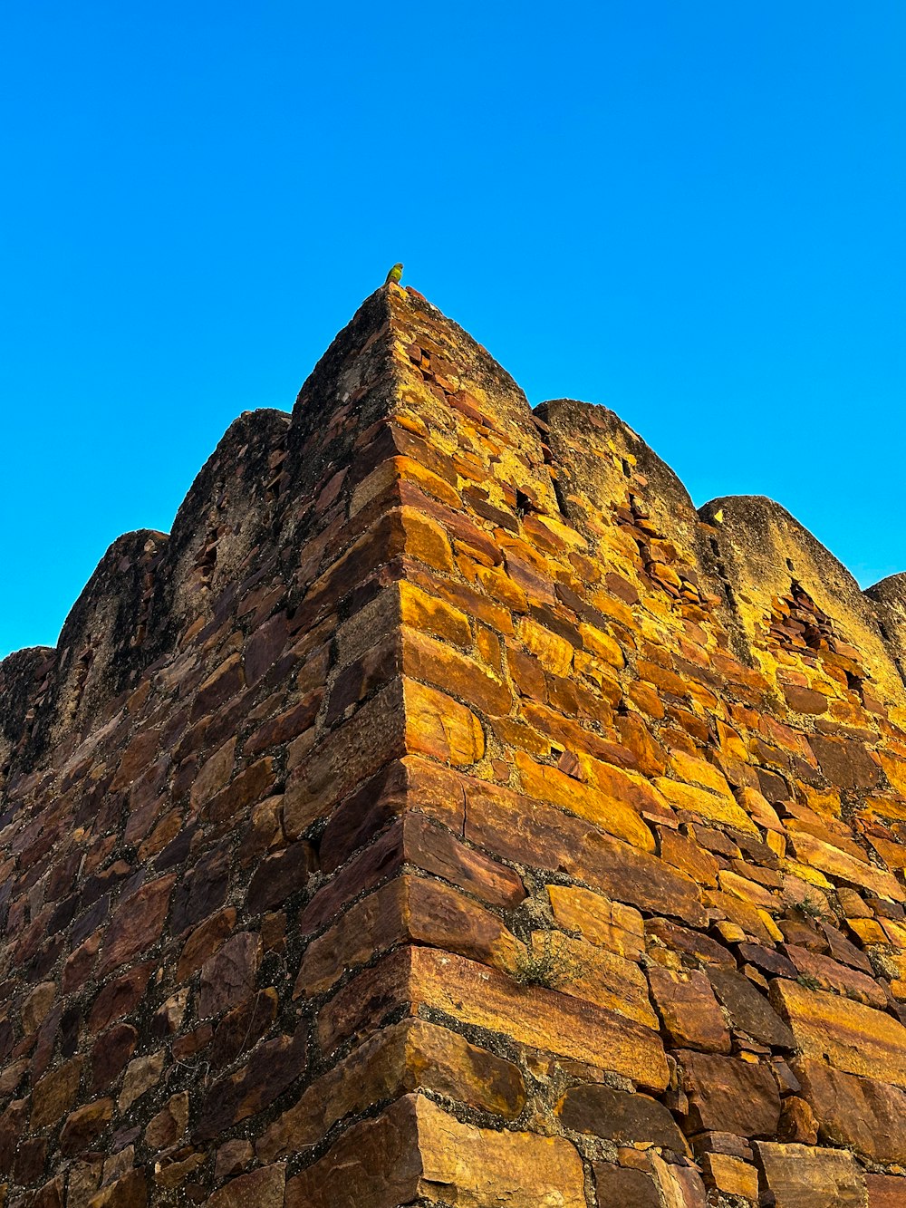 a very tall brick structure with a sky in the background