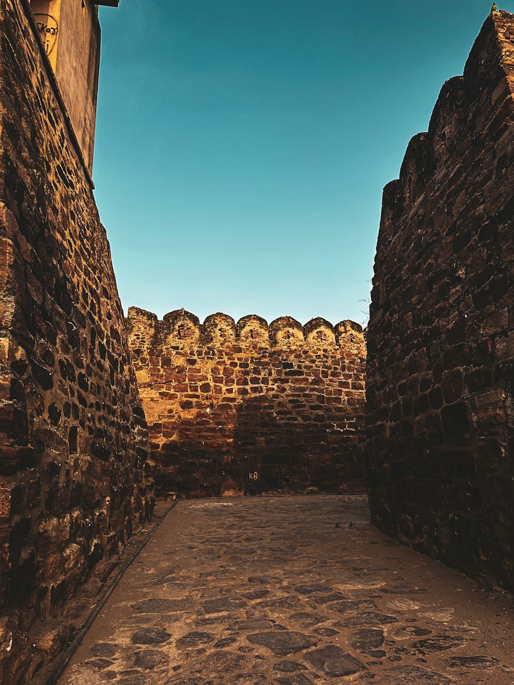 a narrow alley way with a clock on the wall