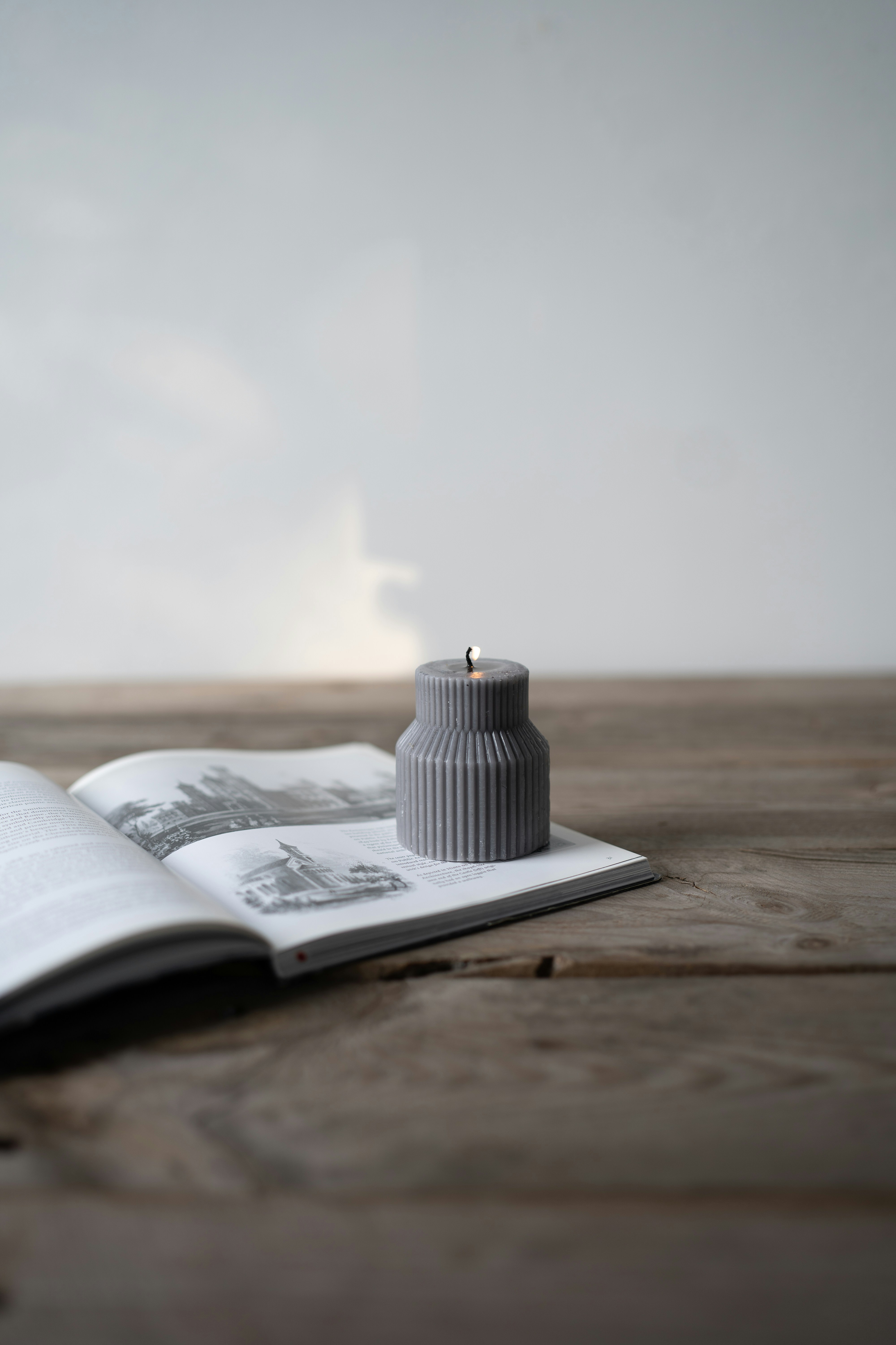 Open book with yellowed pages, candlelight illuminating poetry text, dark moody atmosphere, wooden table