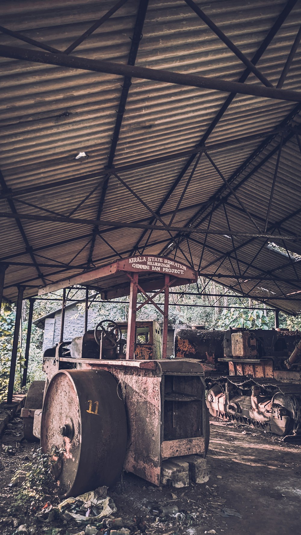 Uma máquina velha e enferrujada está sob um telhado