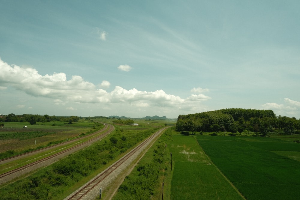 a train track running through a lush green countryside