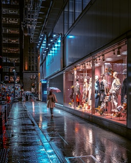 a woman walking down a street holding an umbrella