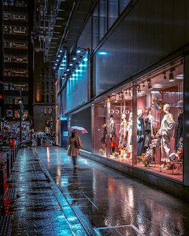 a woman walking down a street holding an umbrella