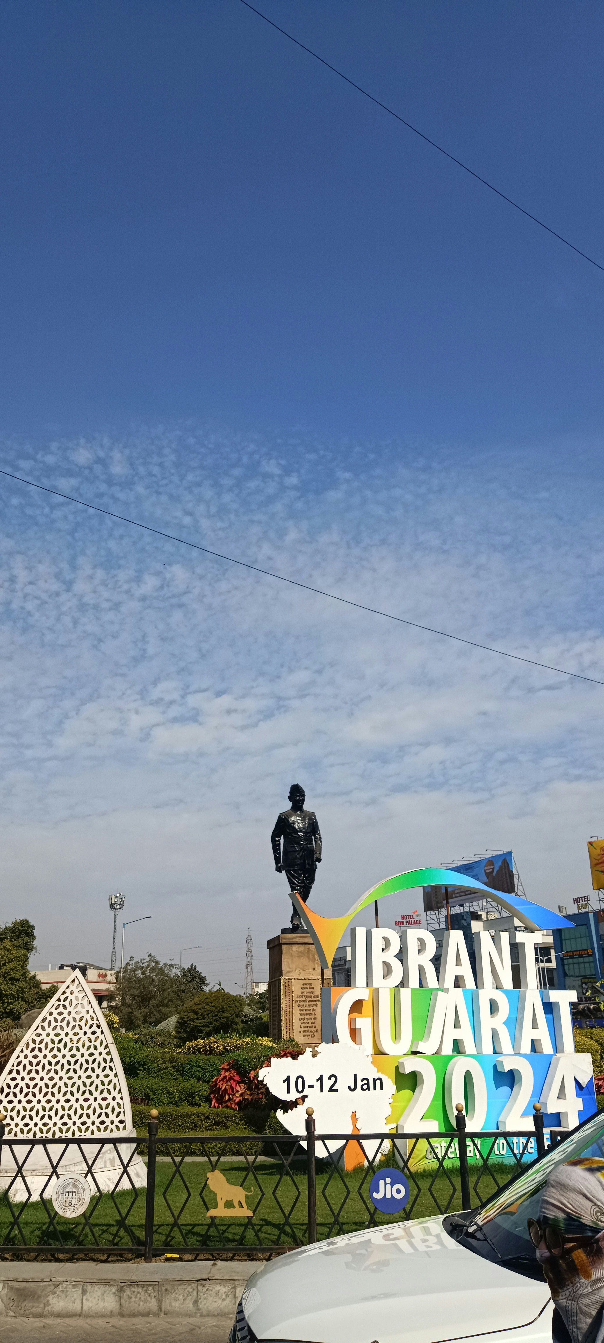 a white car parked in front of a large sign