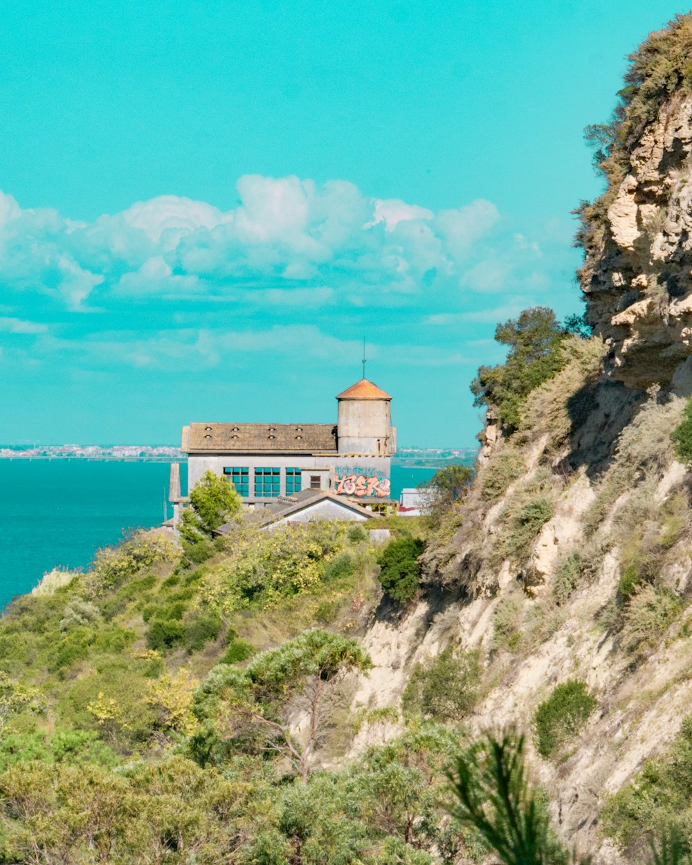 a building on a hill overlooking the ocean