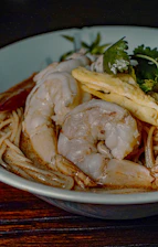 a white bowl filled with noodles and shrimp