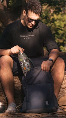 a man sitting on a log with a backpack