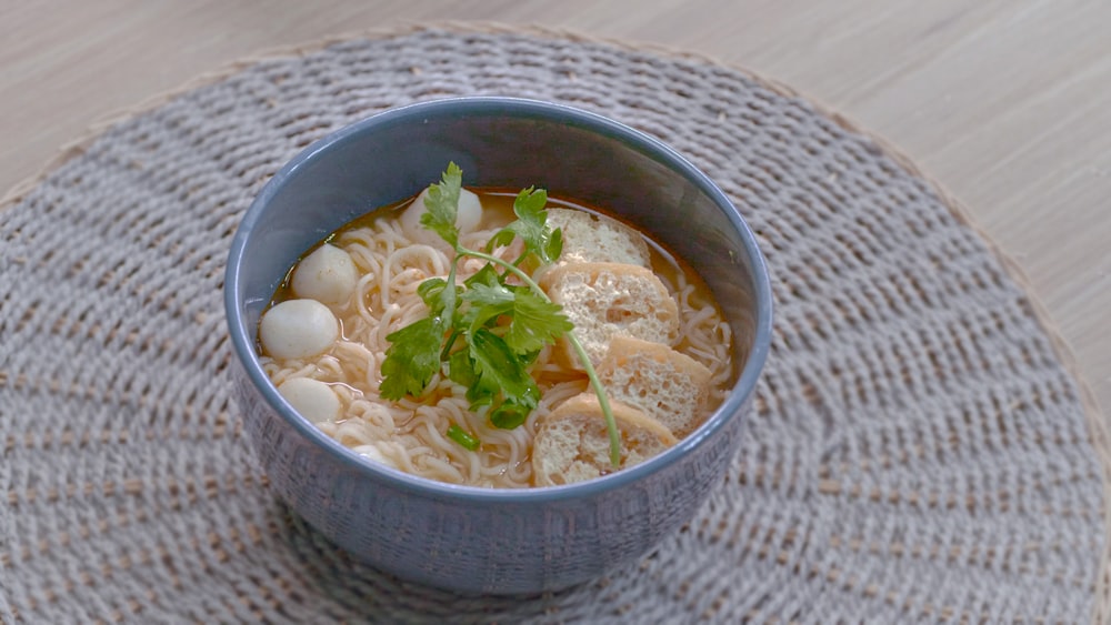 a blue bowl of soup on a table