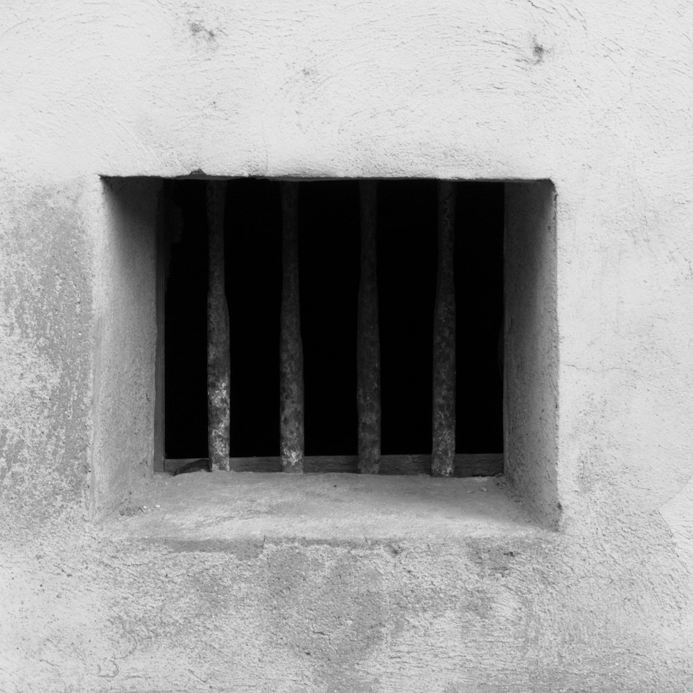 a barred window in a concrete wall with bars