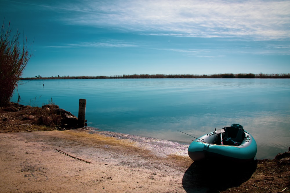 una piccola barca seduta sulla riva di un lago