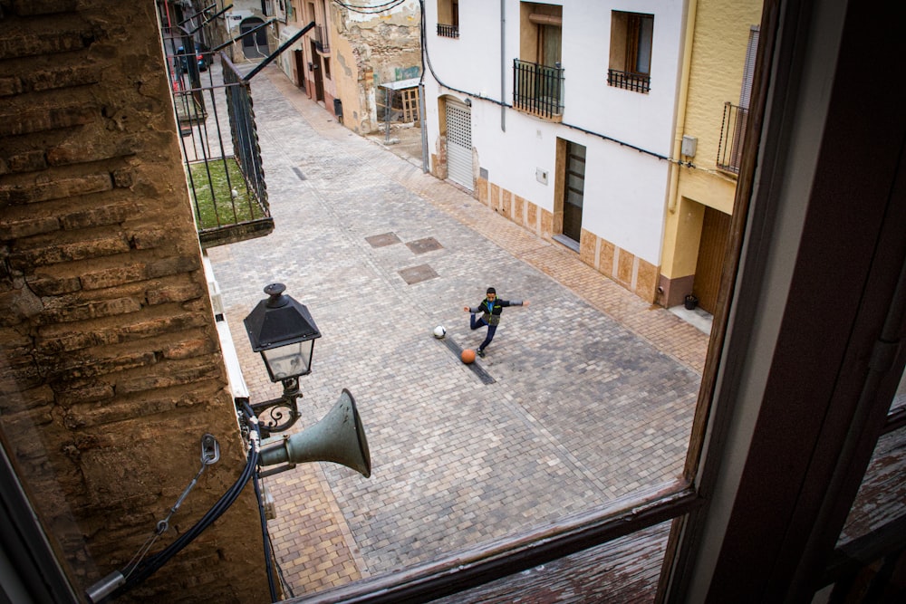 a man riding a skateboard down a street next to a tall building