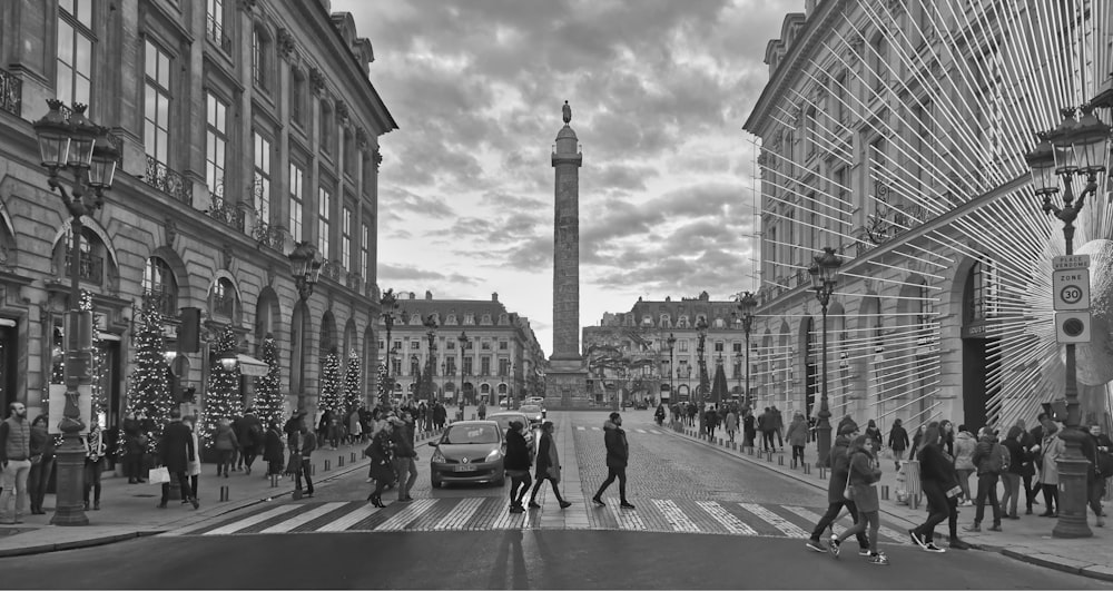 a black and white photo of people crossing the street