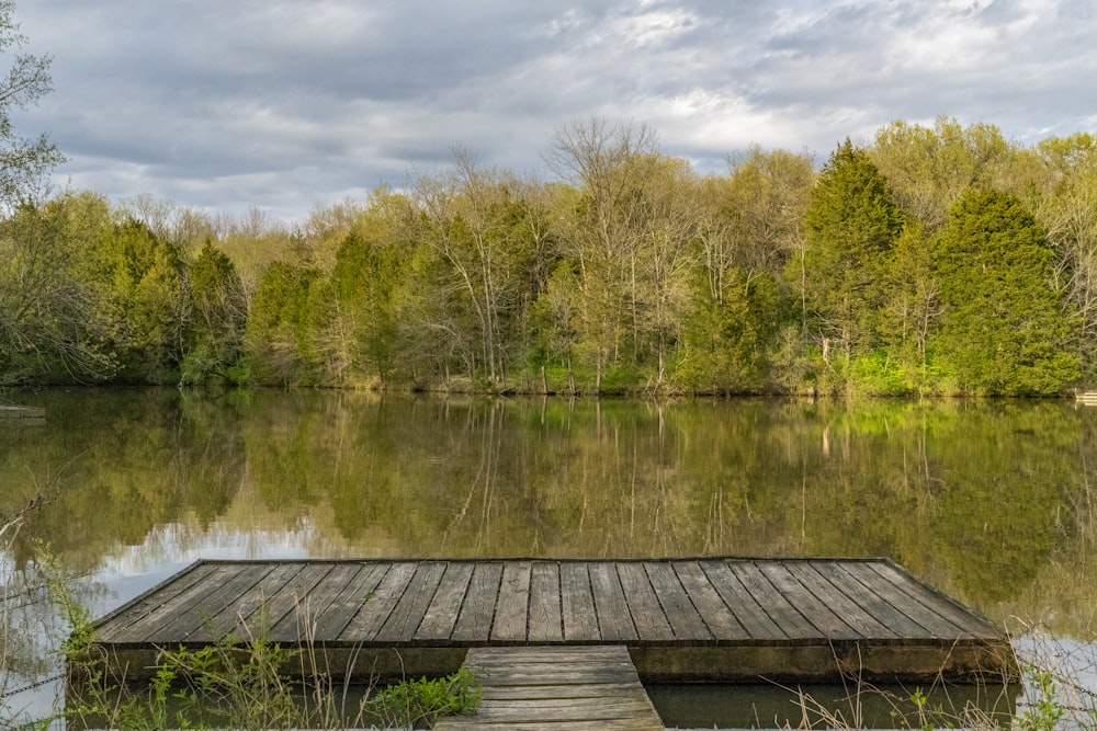 a dock sitting on top of a lake next to a forest