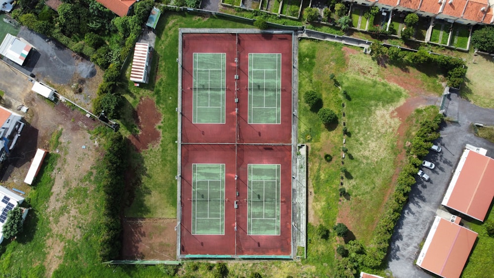 an aerial view of a tennis court in a residential area