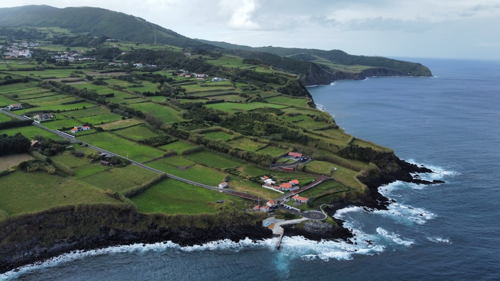 an aerial view of a small village on the edge of a large body of water