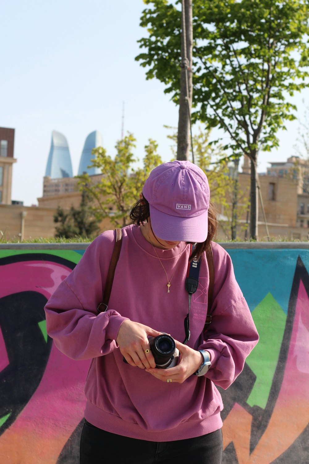 a woman standing in front of a wall with a camera