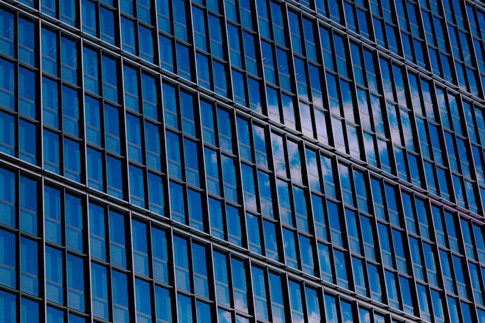 a very tall building with many windows and a plane flying in the sky