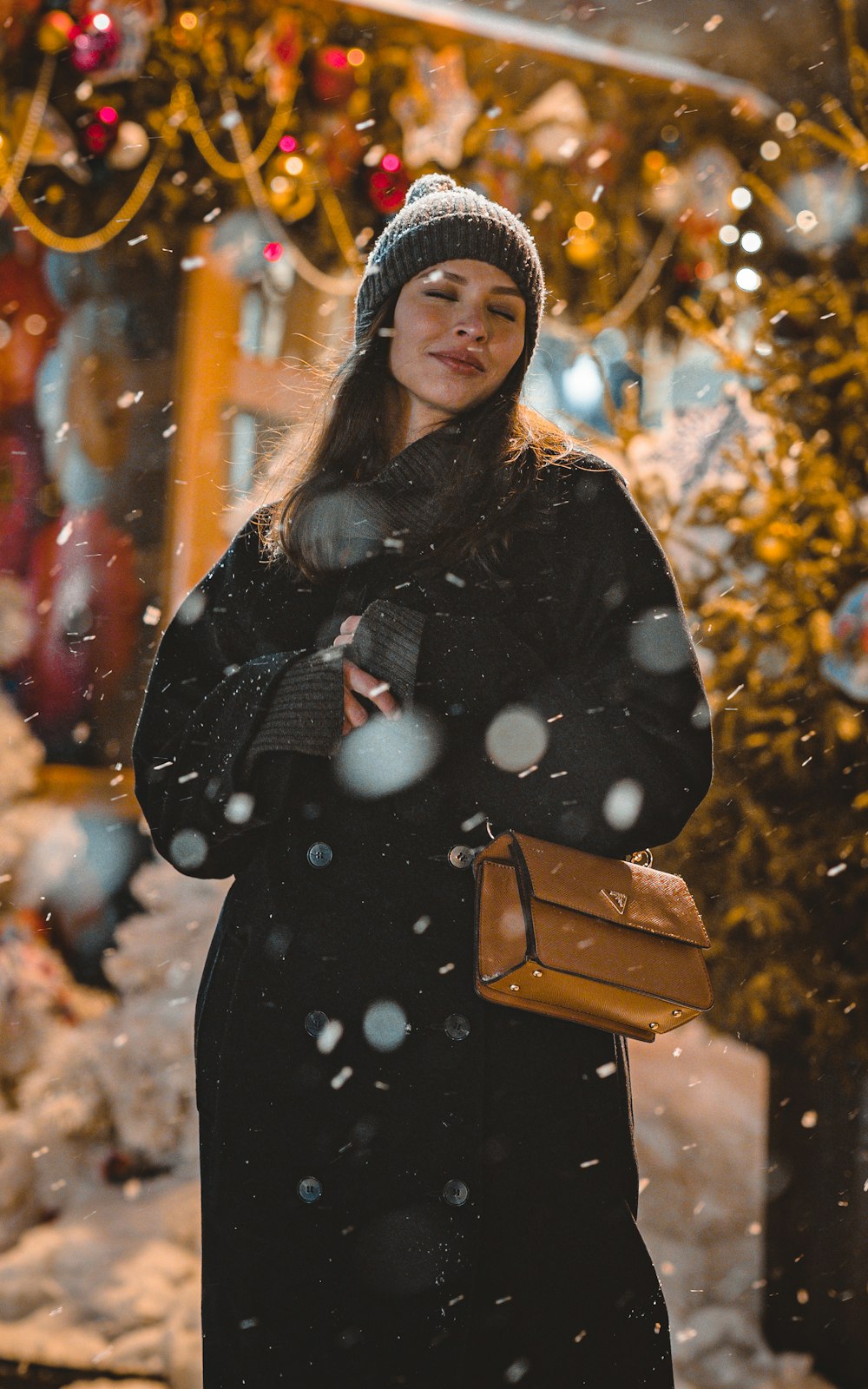 a woman standing in front of a christmas tree