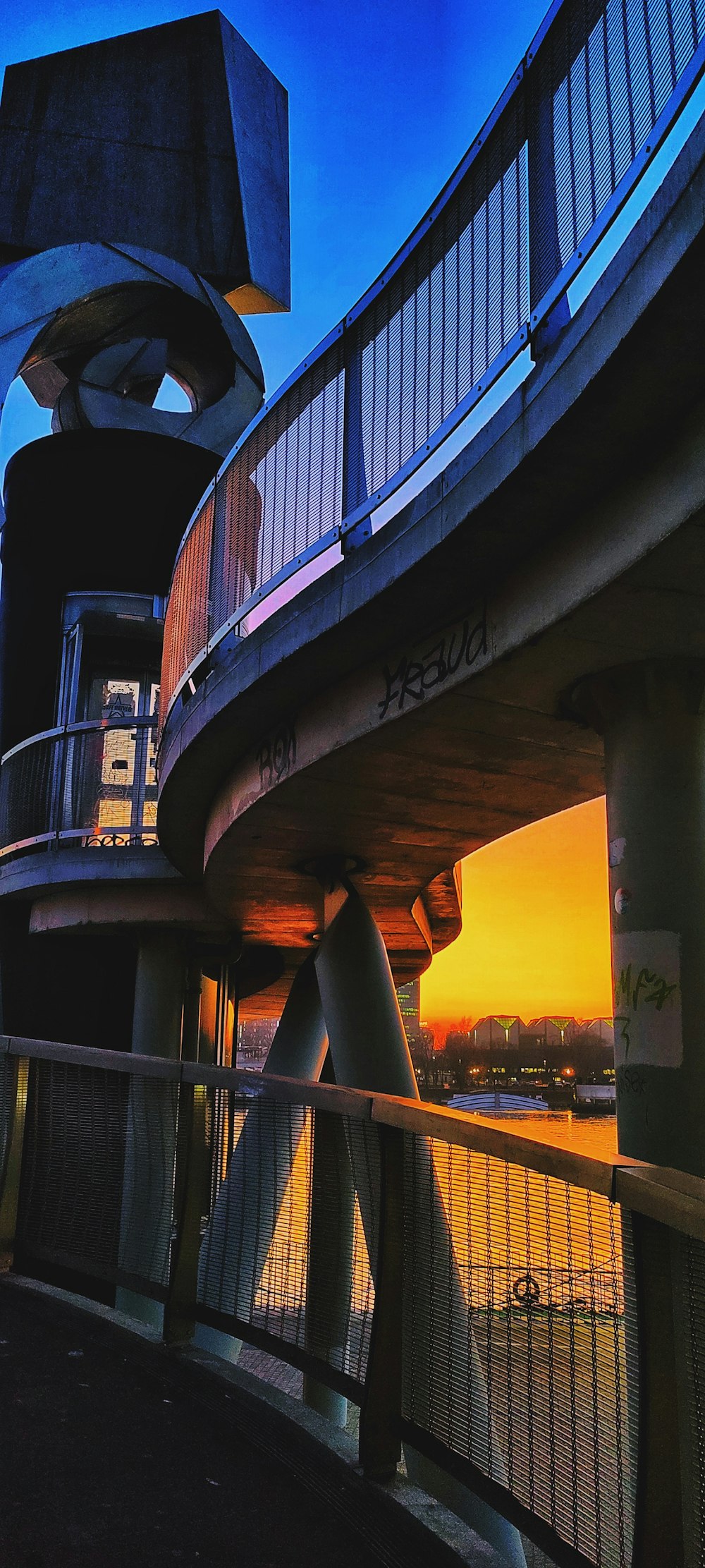 un edificio alto con un balcone vicino a uno specchio d'acqua