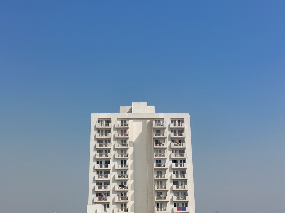 a tall white building sitting on the side of a beach