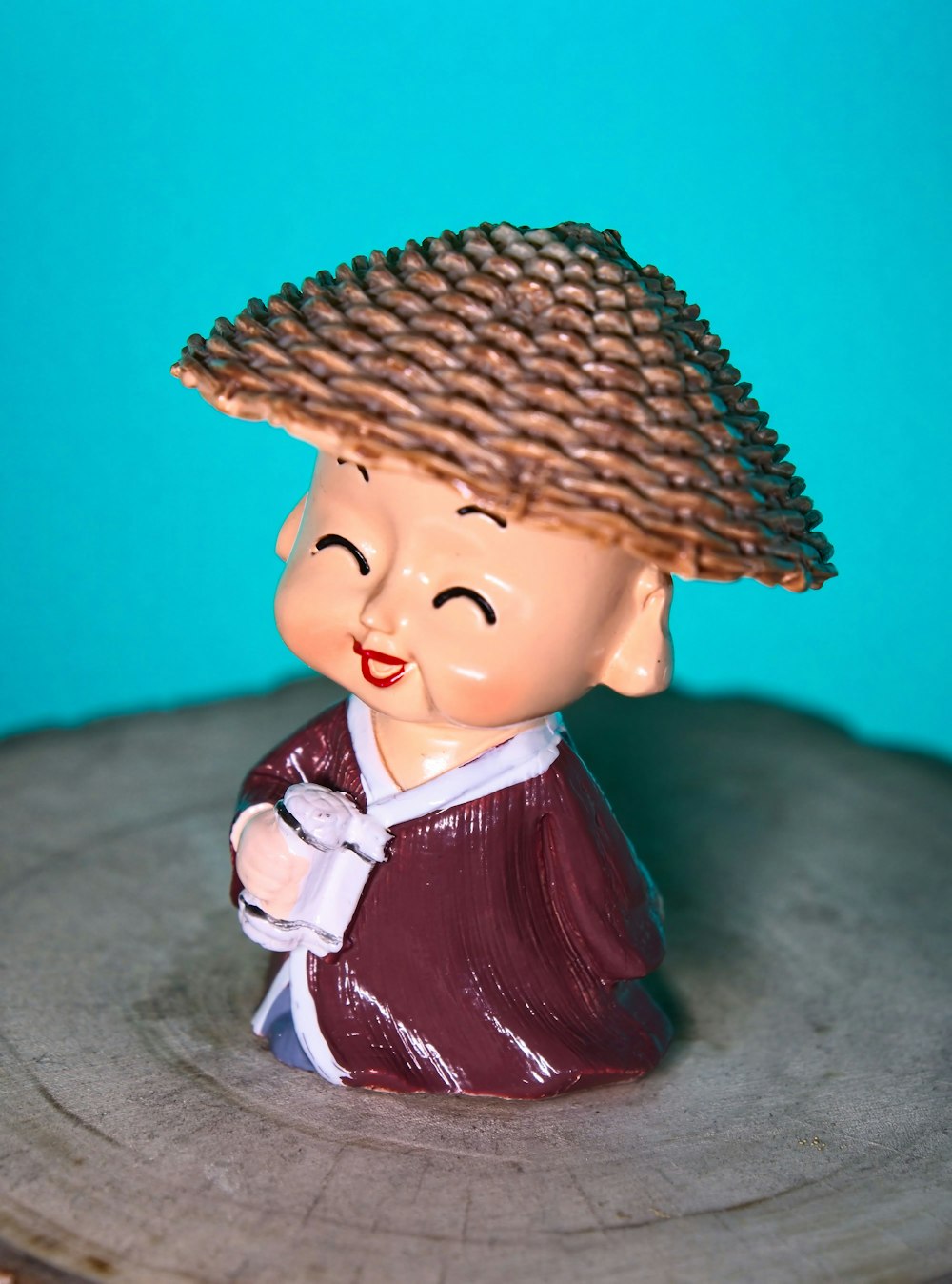 a small figurine of a boy with a straw hat