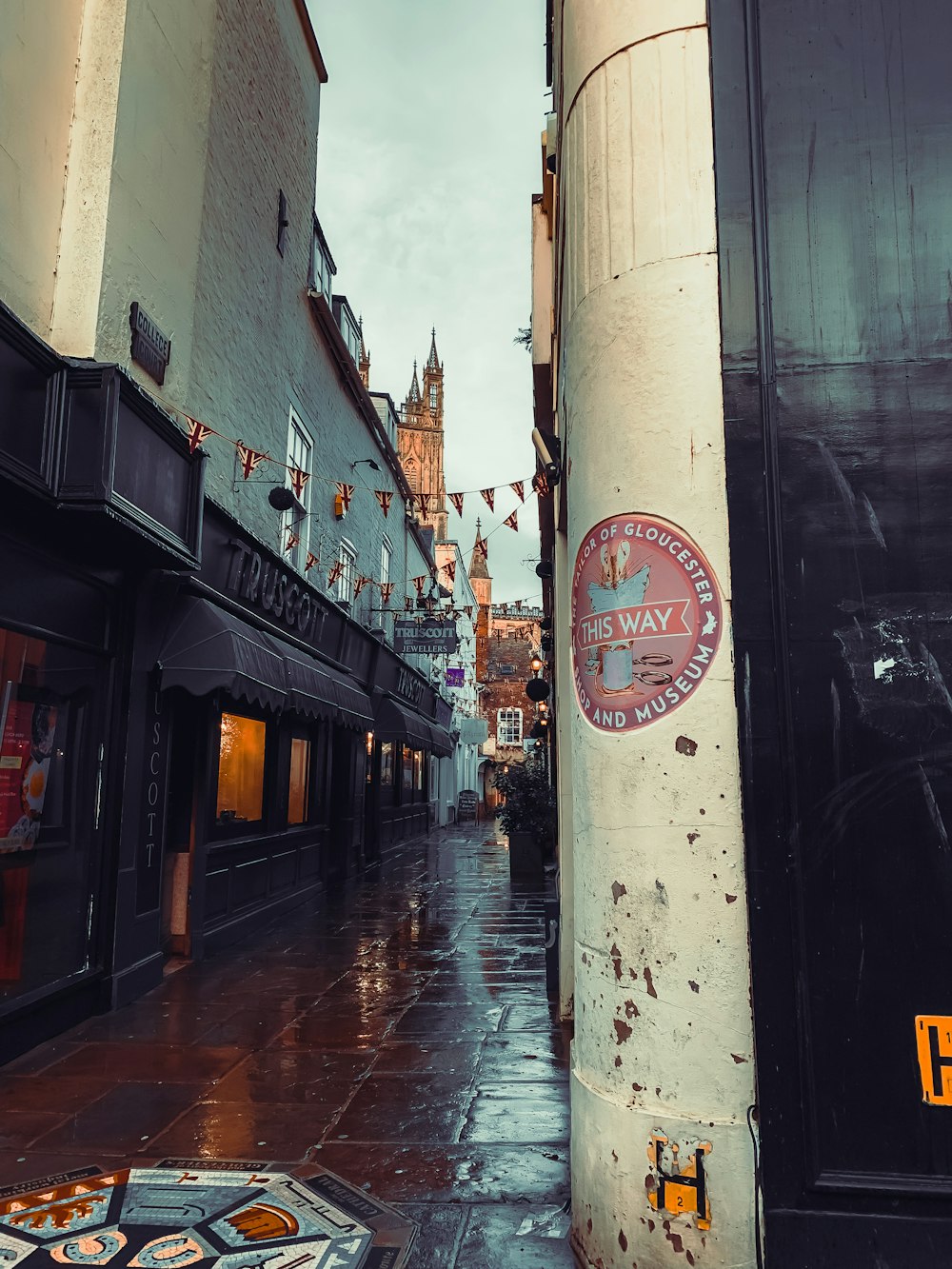 a wet street with a sign on the side of it